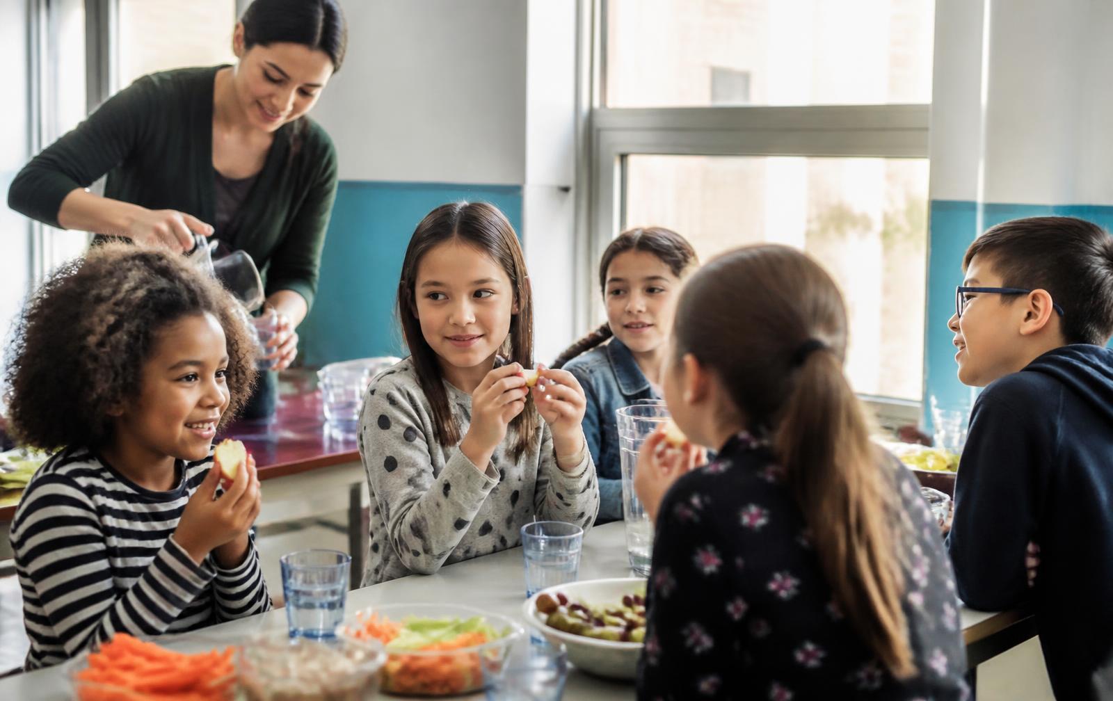 Children sharing an after-school snack with an educator at Oakville Learning Academy