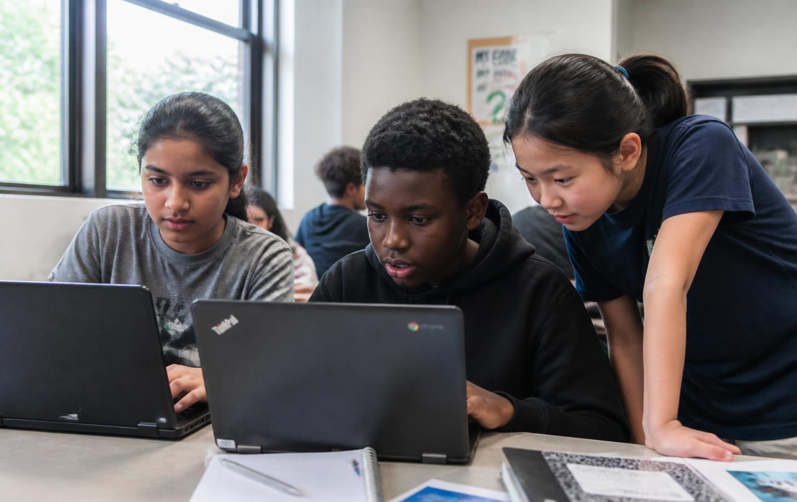 Children programming apps on laptops