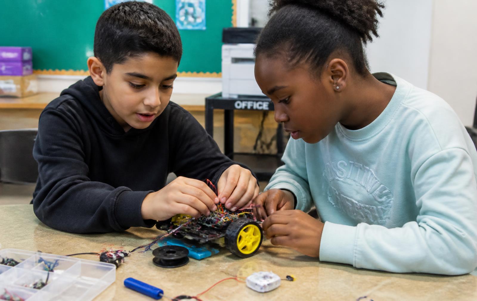 Children building a LEGO robotics kit at summer camp