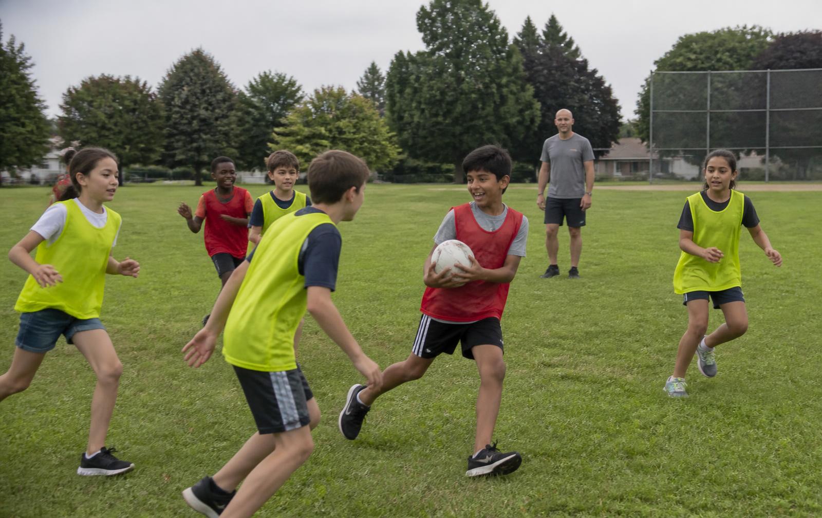 Children playing soccer and relay races at summer camp
